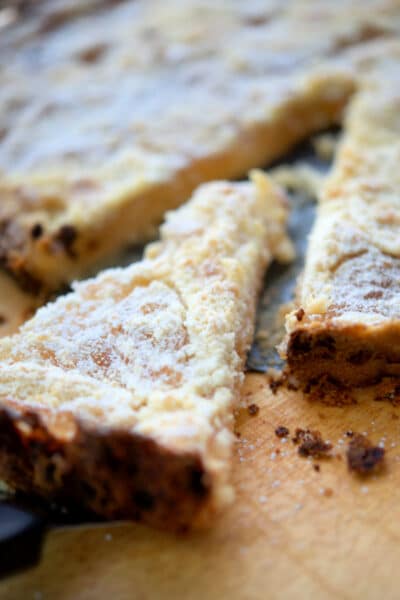 a piece of an apple pie tart cut out on a wooden board