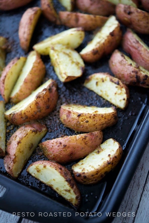  potato wedges with pesto on a sheet pan