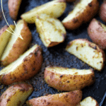 pesto roasted potato wedges on a sheet pan