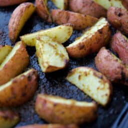 a close up of potato wedges on a sheet pan