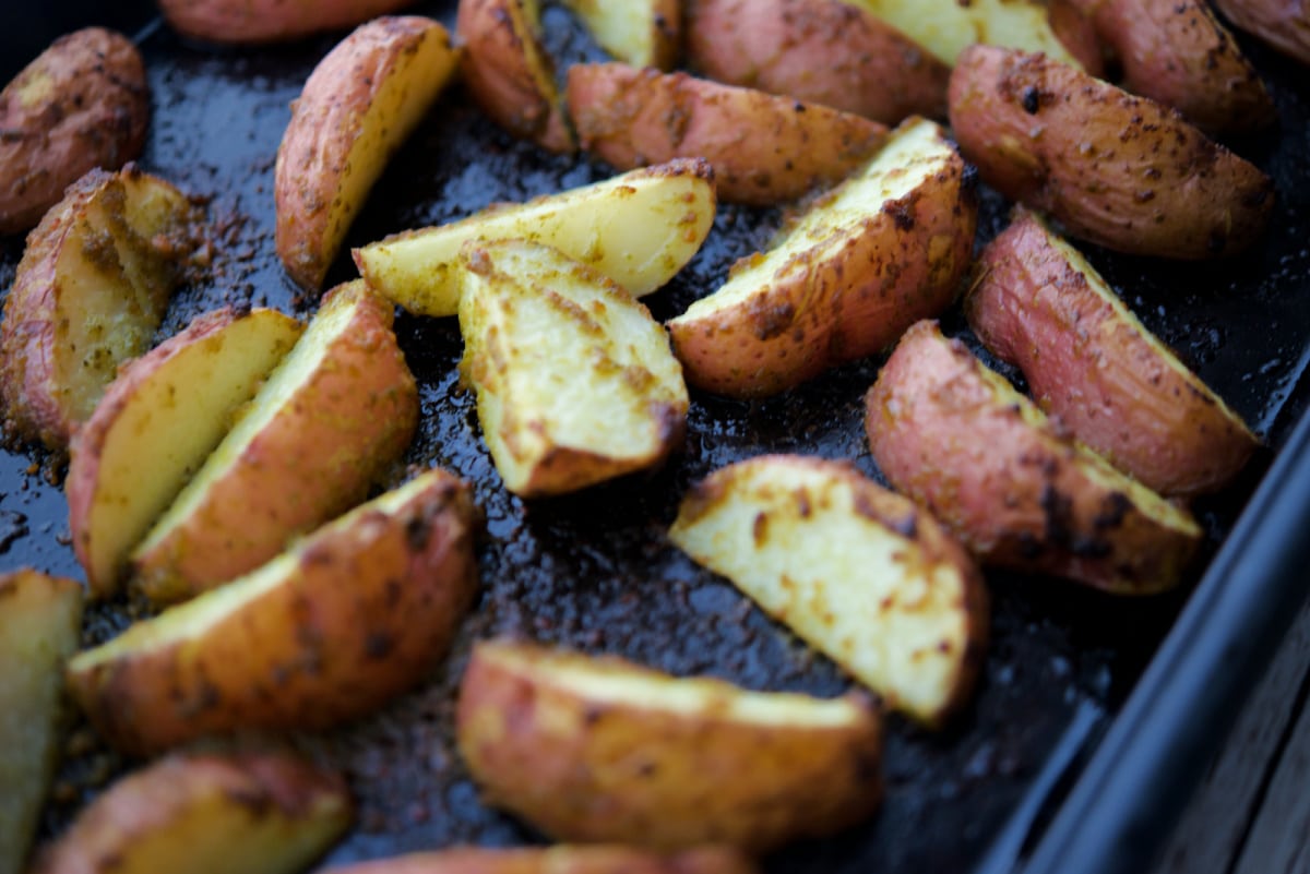 a close up of potato wedges on a sheet pan