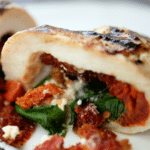stuffed chicken cut in half with sun dried tomatoes, spinach and goat cheese