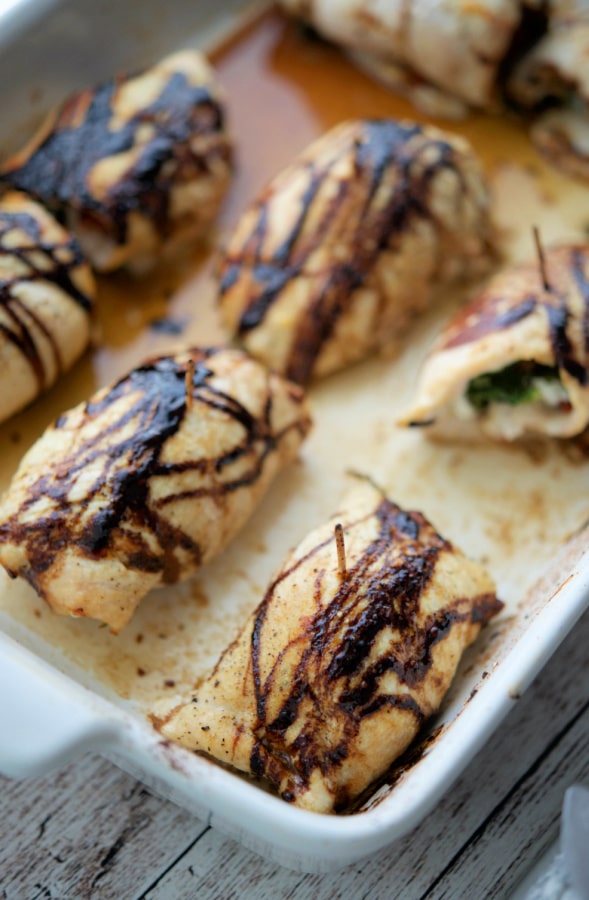 stuffed chicken in a pan with balsamic drizzle