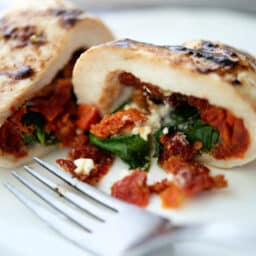 stuffed chicken cut in half on a white plate