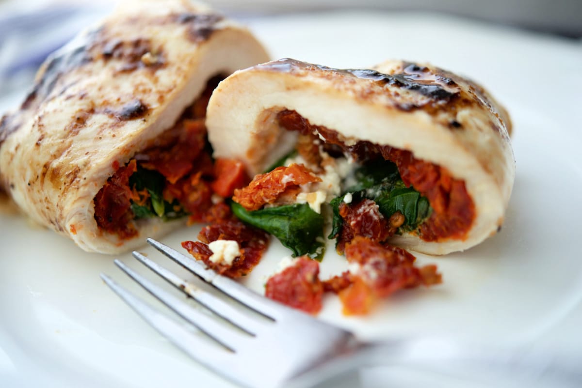 stuffed chicken cut in half on a white plate