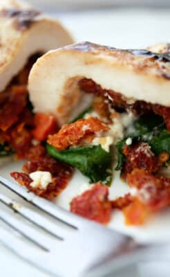 chicken stuffed with sun dried tomatoes spinach and goat cheese on a plate