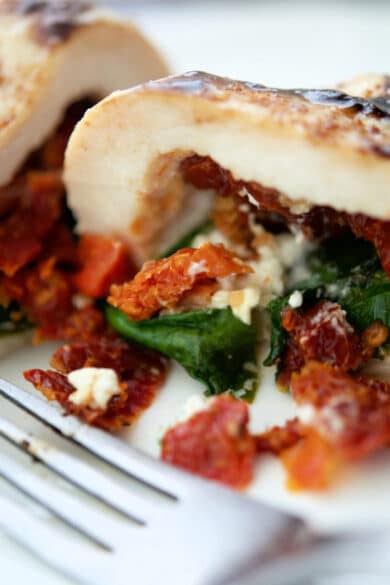 chicken stuffed with sun dried tomatoes spinach and goat cheese on a plate