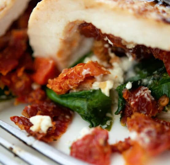 chicken stuffed with sun dried tomatoes spinach and goat cheese on a plate