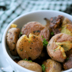 a bowl of butter and parsley smashed potatoes