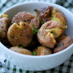 a close up of parsley smashed potatoes