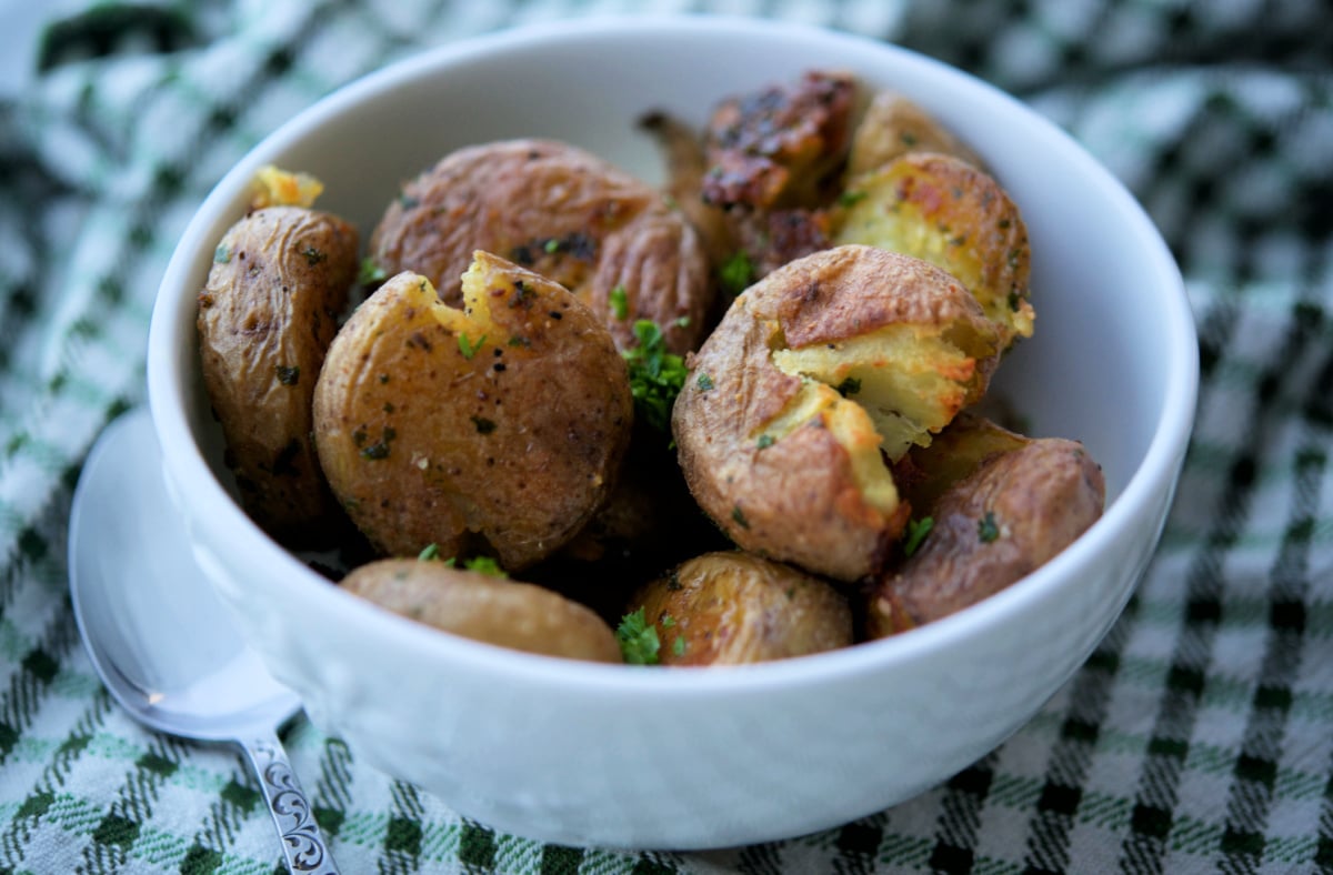 a close up of parsley smashed potatoes