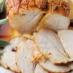 half carved maple butter roasted turkey breast on a white plate