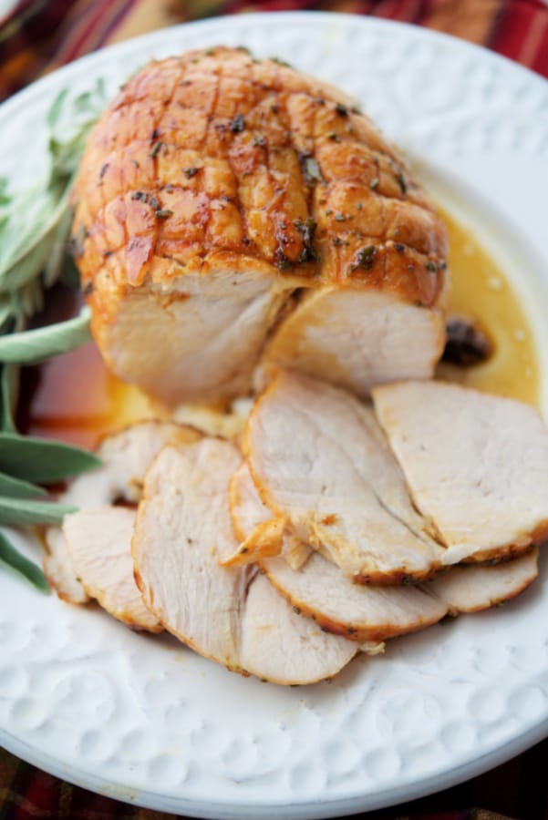 maple butter roasted turkey breast half carved on a white plate