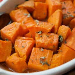 a close up of maple sweet potatoes in a white dish