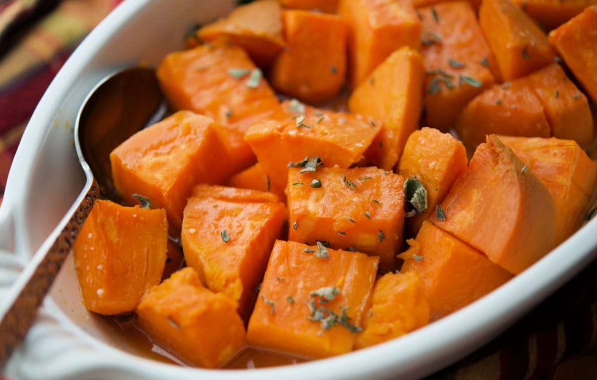 a close up of maple sweet potatoes in a white dish