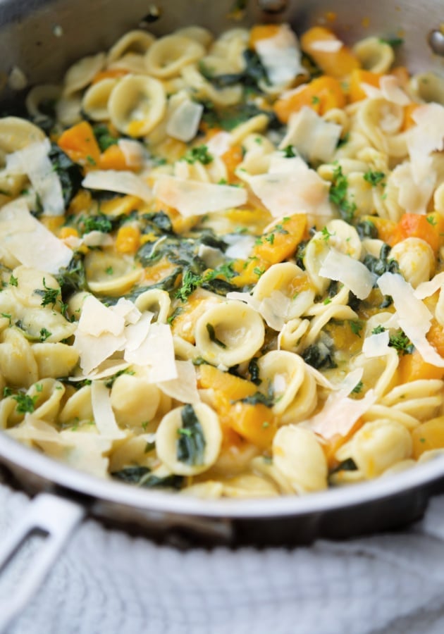 pasta in a skillet with squash and spinach