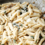 cooked cavatelli pasta in a skillet with walnuts and sage