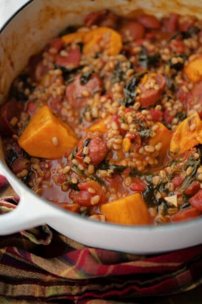 sweet potato, chourico and spinach stew in a white Dutch oven