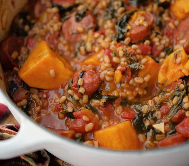 sweet potato, chourico and spinach stew in a white Dutch oven