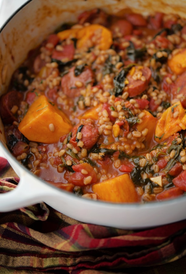 sweet potato, chourico and spinach stew in a white Dutch oven