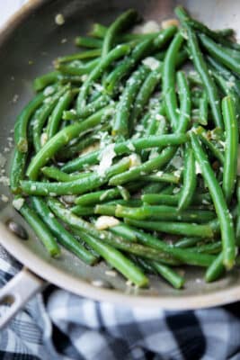 a skillet with cooked green beans and garlic