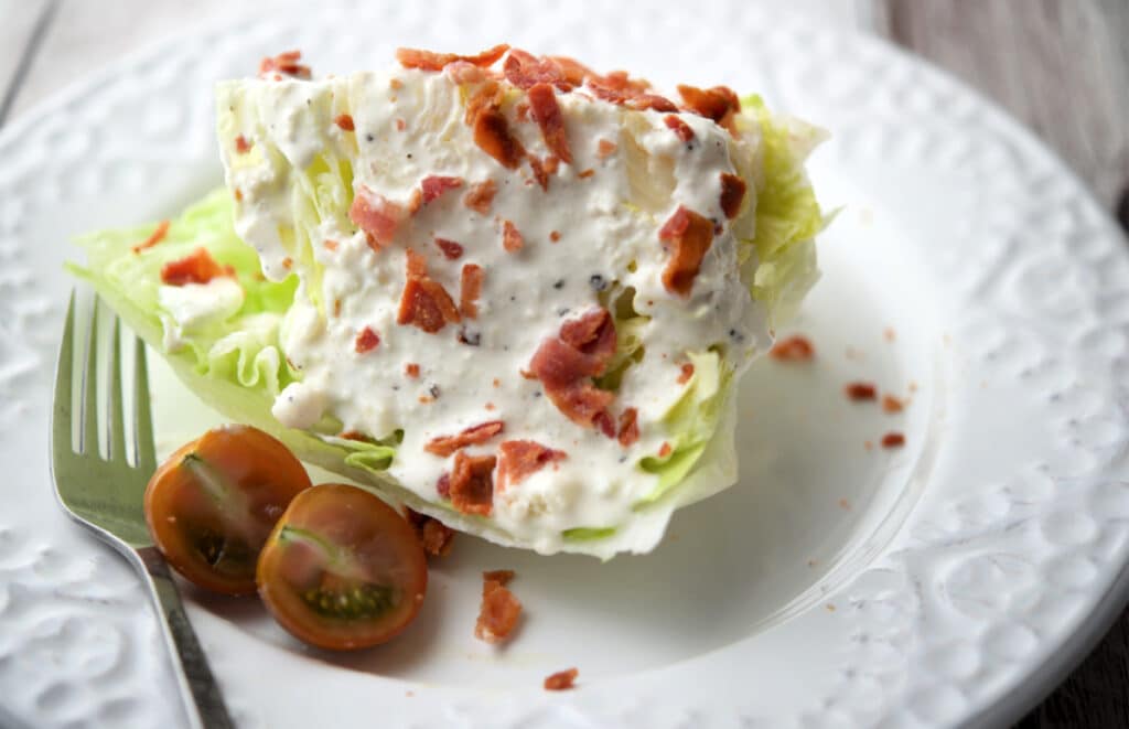 a close up of a wedge salad on a white plate