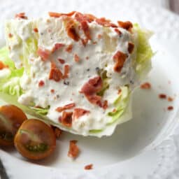 a close up of a wedge salad on a white plate