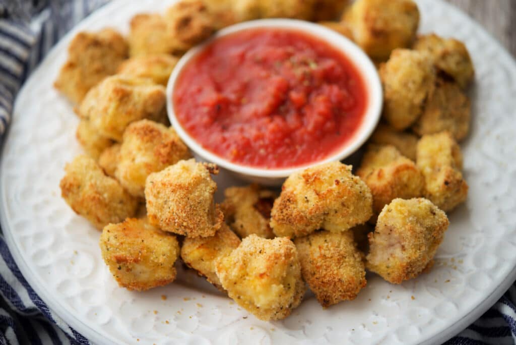 a close up of italian chicken nuggets on a plate with sauce