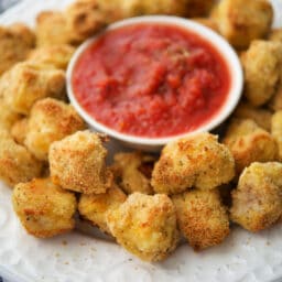 a close up of italian chicken nuggets on a plate with sauce