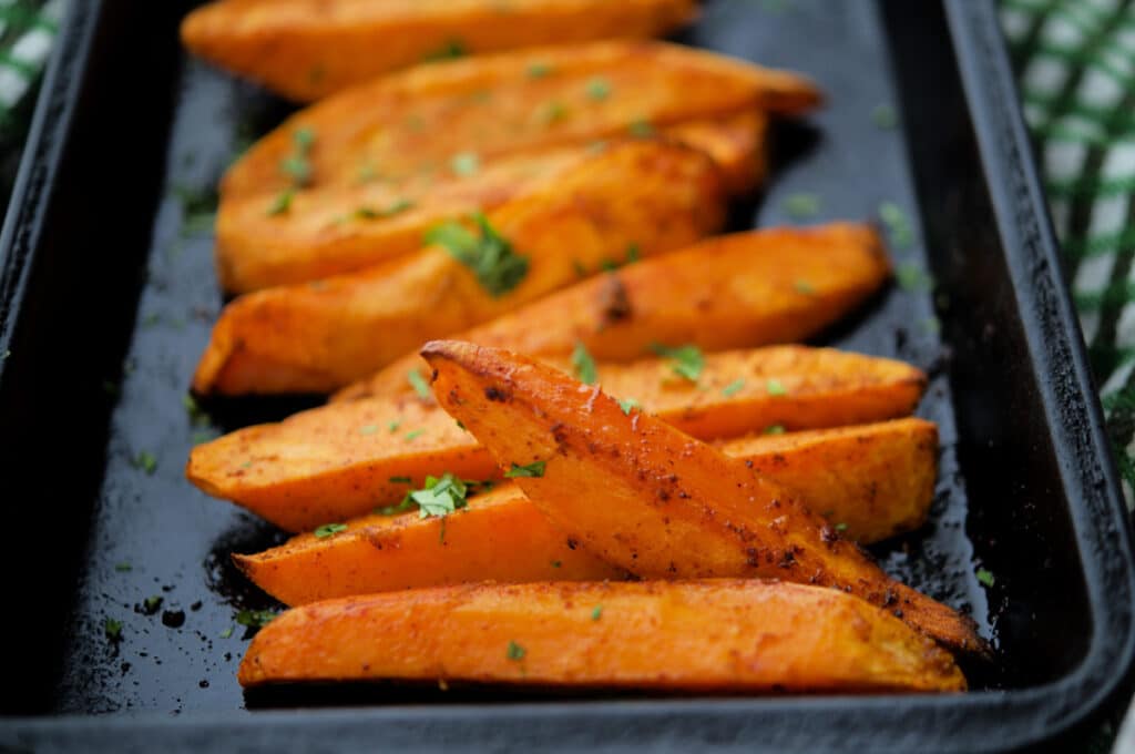 roasted chili lime sweet potato wedges in a small roasting pan