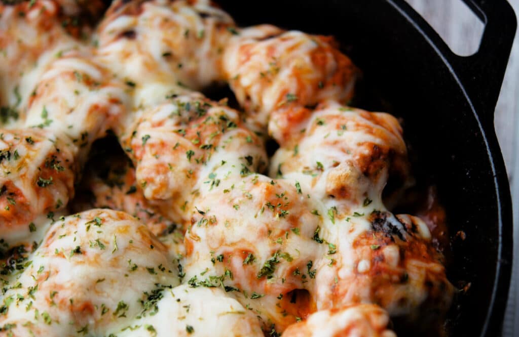 a close up of italian meatballs in a skillet