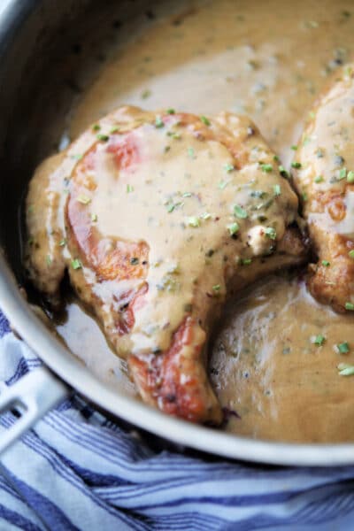 pork chops in honey mustard cream sauce in a skillet