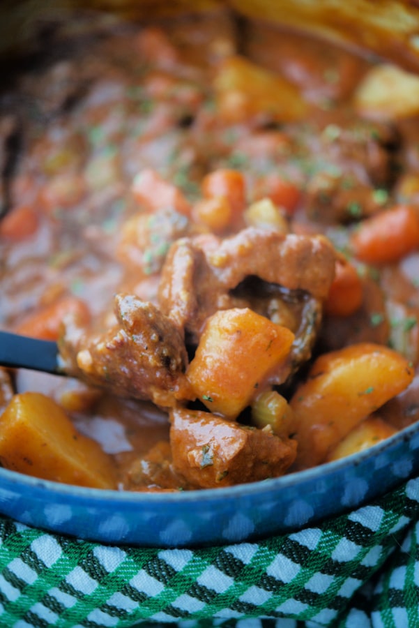 a close up of irish beef stew on a spoon