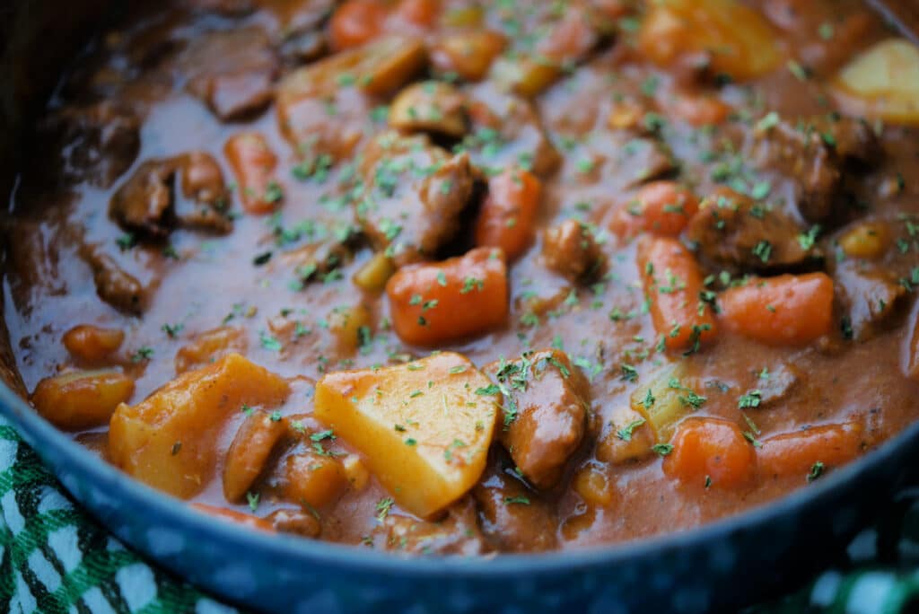 a close up of irish beef stew in a dutch oven