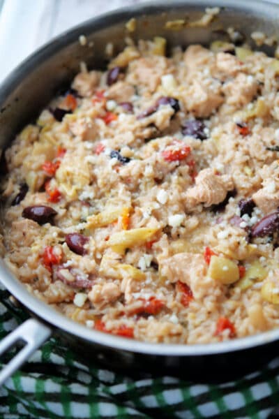 a skillet with cooked risotto with chicken, olives and artichoke hearts