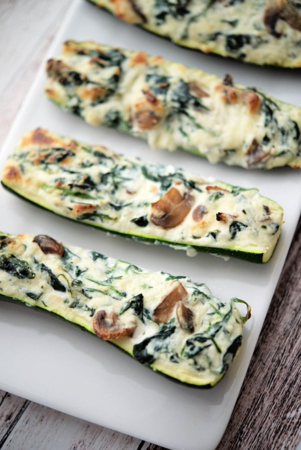 spinach ricotta zucchini boats on a white dish