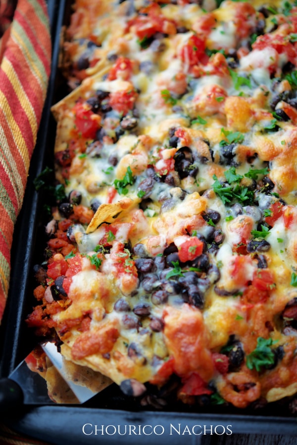 a pan of nachos with beans and chourico