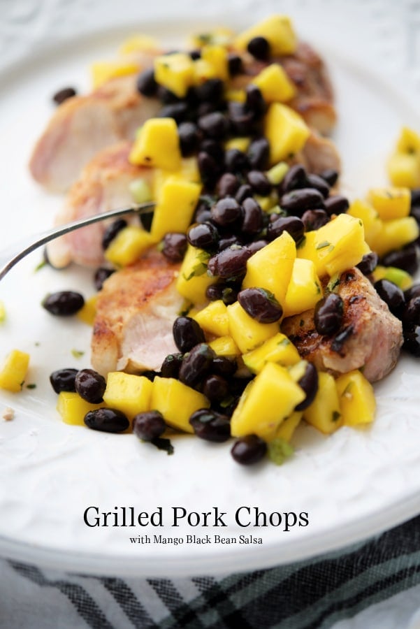 pork chops with mango black bean salsa on a white plate