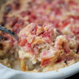 a close up of baked oatmeal with strawberries on a spoon