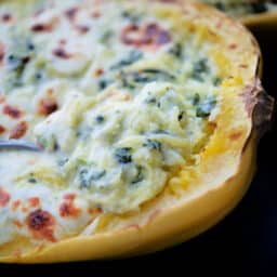 a close up of spinach alfredo spaghetti squash on a spoon