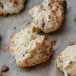 a close up of bacon and cheddar drop biscuits on a pan