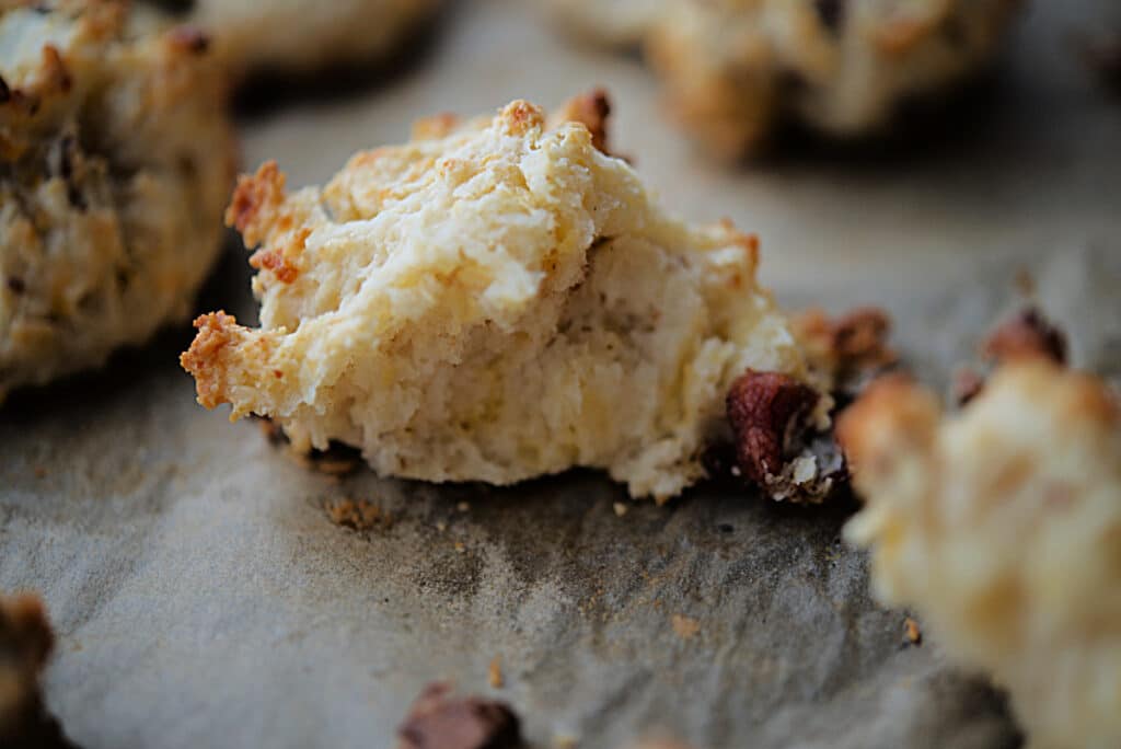 a close up of a bacon and cheddar drop biscuit