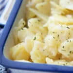 a close up of otto's copycat german potato salad in a white and blue dish