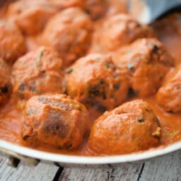 a close up of zucchini meatballs in a pan with vodka sauce