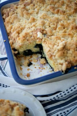 a blue and white baking dish with blueberry cream cheese coffee cake
