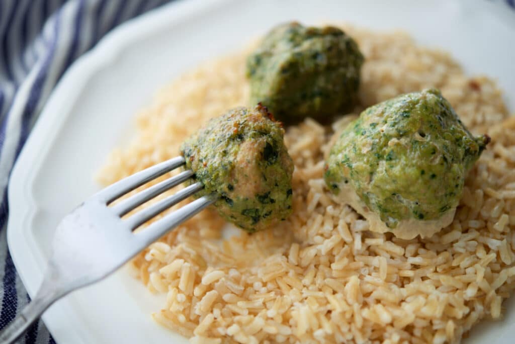 spinach turkey meatballs over rice on a fork