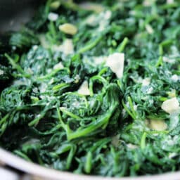 a close up of spinach with garlic and parmesan