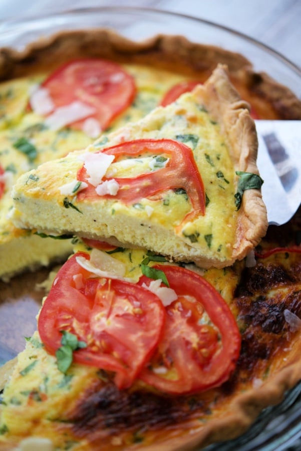 a slice of tomato ricotta quiche on a pie server