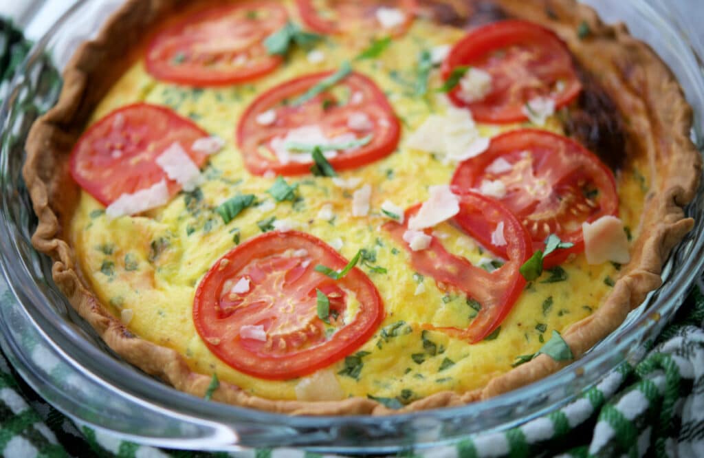 close up of a quiche with tomatoes