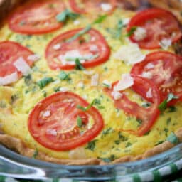 close up of a quiche with tomatoes
